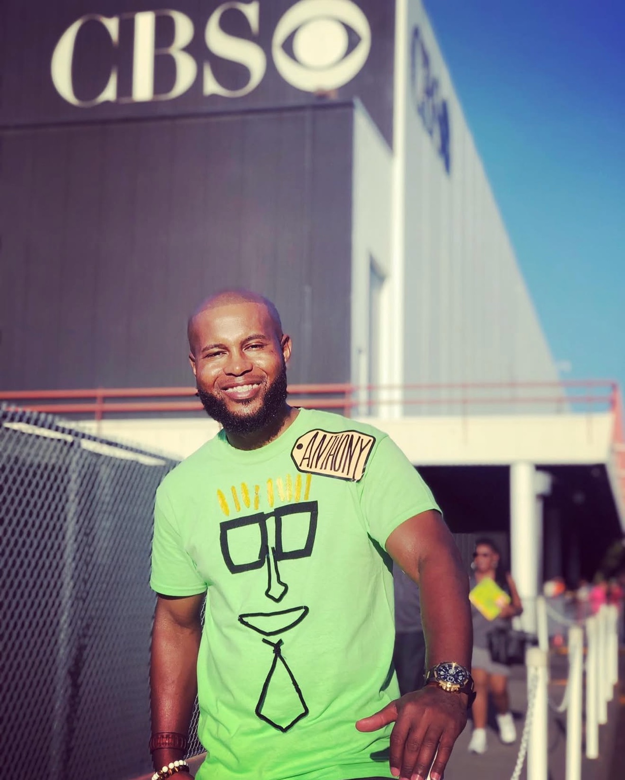 Anthony Alexander wearing a green shirt and an Anthony name tag outside CBS for his 2019 appearance