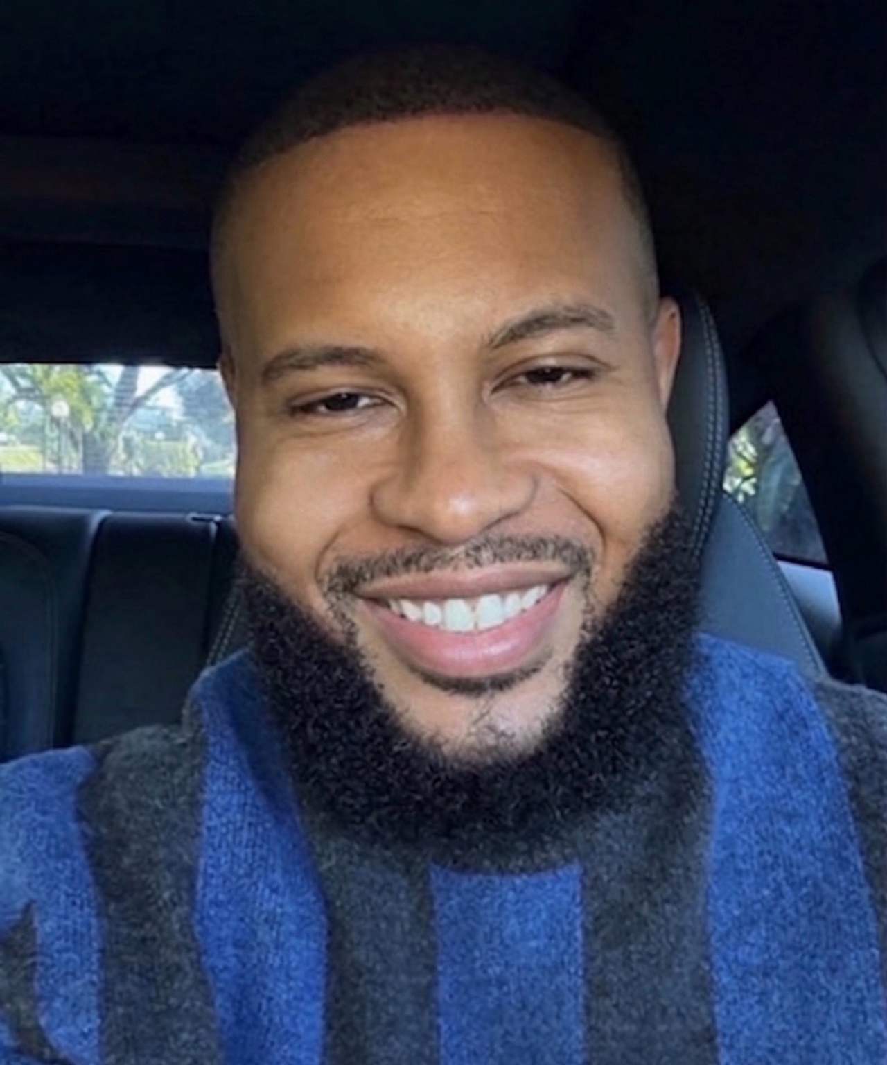 Anthony Alexander smiling in a blue sweater